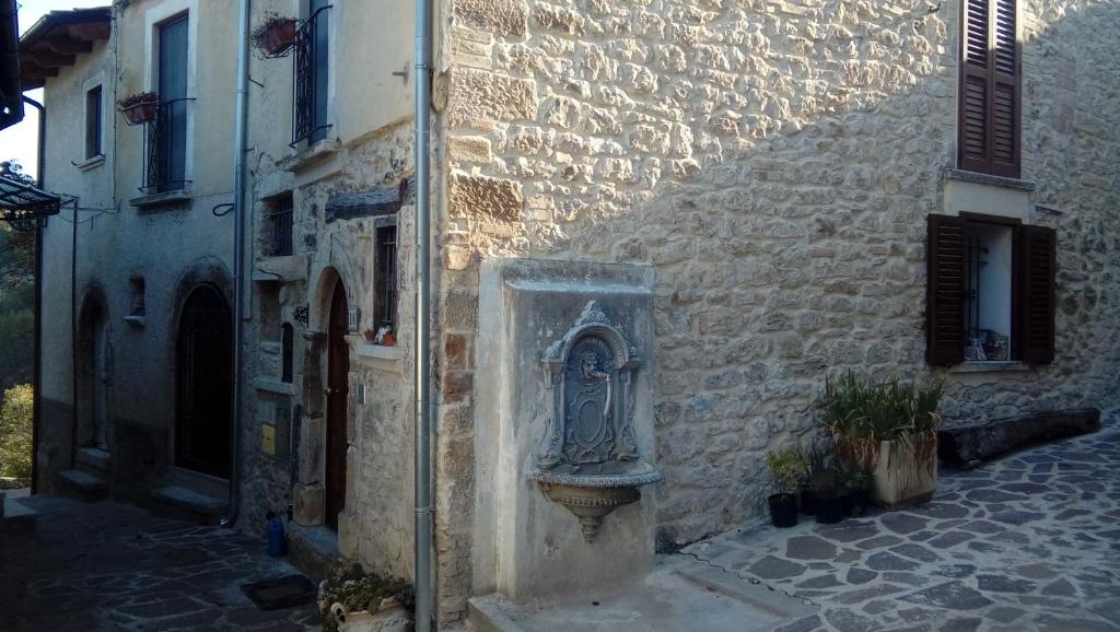a stone building with a statue on the side of it at La maison de Martine in Bolognano