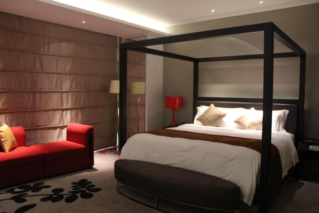 a bedroom with a large bed and a red chair at Wongtee V Hotel in Shenzhen