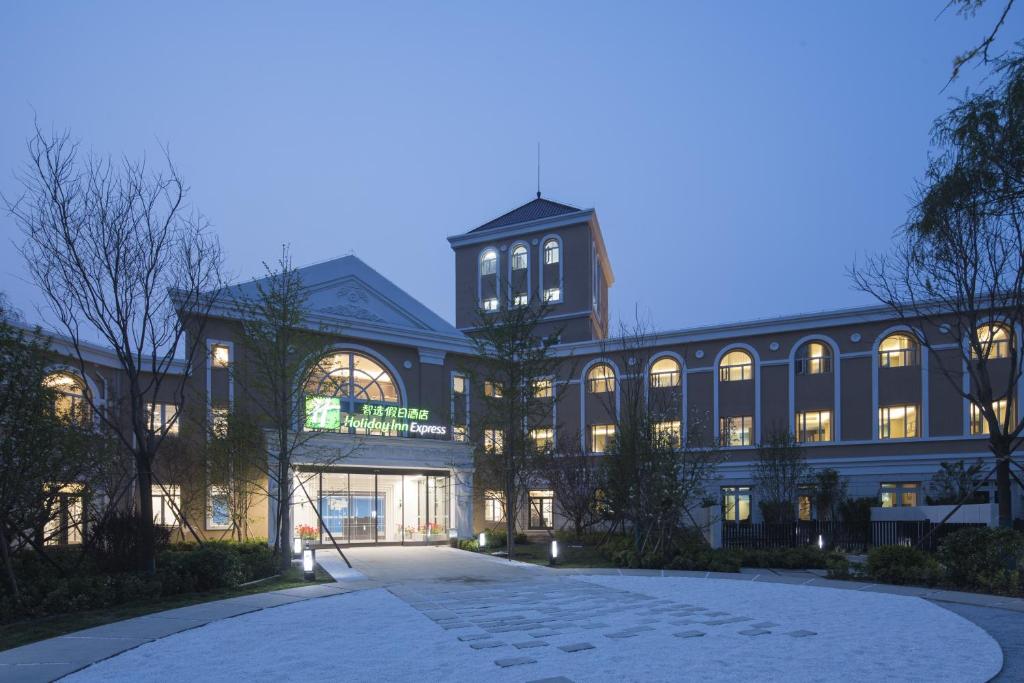 un gran edificio con sus luces encendidas por la noche en Holiday Inn Express Beijing Badaling, an IHG Hotel, en Yanqing