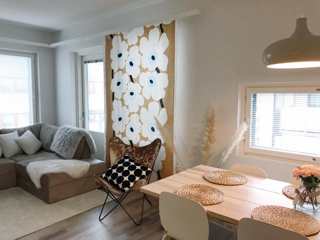 sala de estar con mesa y sofá en Hostit cozy apartment, en Rovaniemi