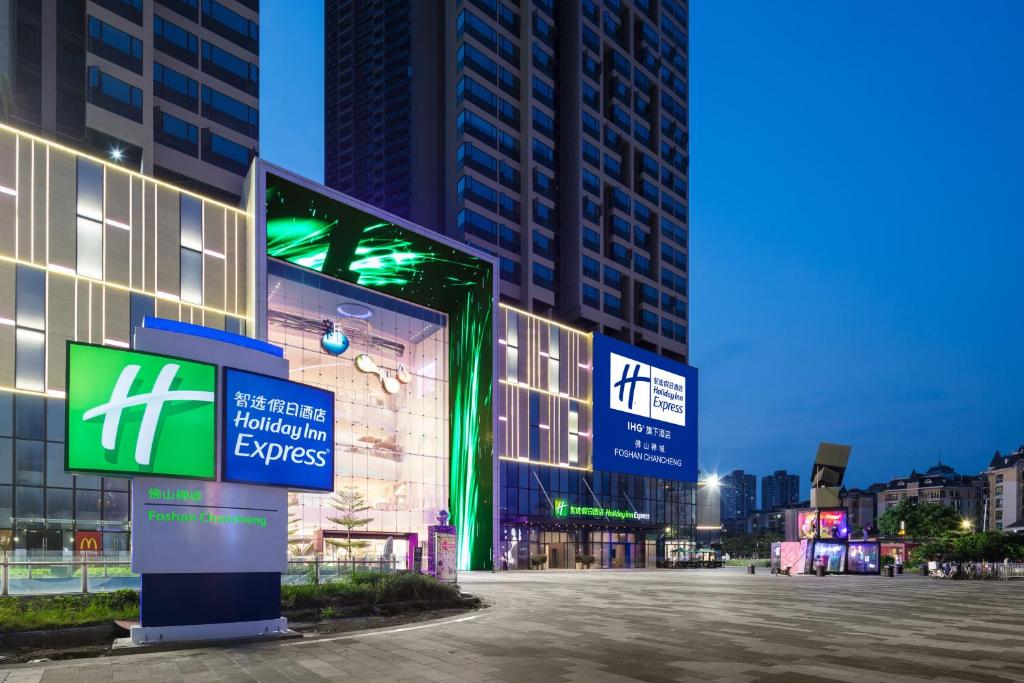 a building with signs in the middle of a street at Holiday Inn Express Foshan Chancheng, an IHG Hotel in Foshan