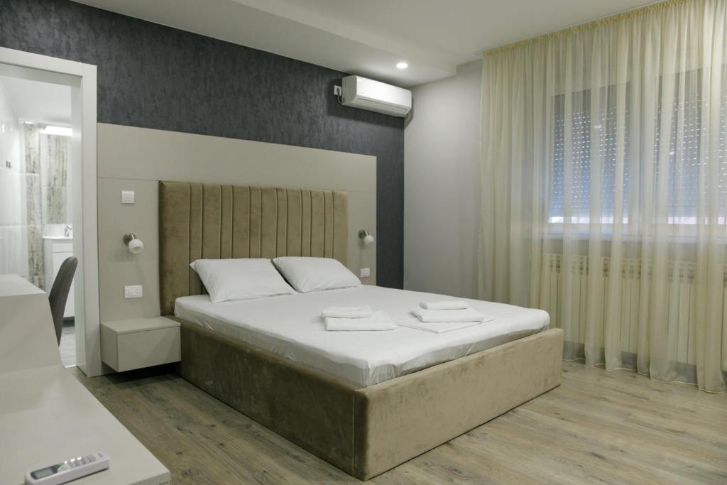 Un dormitorio con una cama grande y una ventana en Fine Suites, en Niš