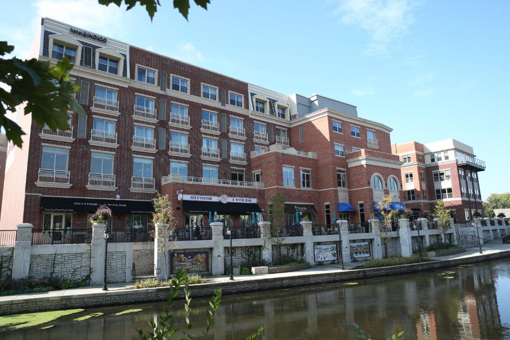 un gran edificio de ladrillo junto a un río en Hotel Indigo Naperville Riverwalk, an IHG Hotel en Naperville