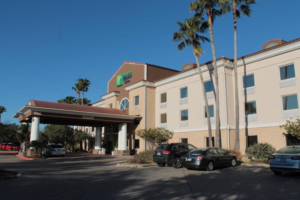 un bâtiment d'hôtel avec des voitures garées devant lui dans l'établissement Holiday Inn Express Hotel and Suites Brownsville, an IHG Hotel, à Brownsville