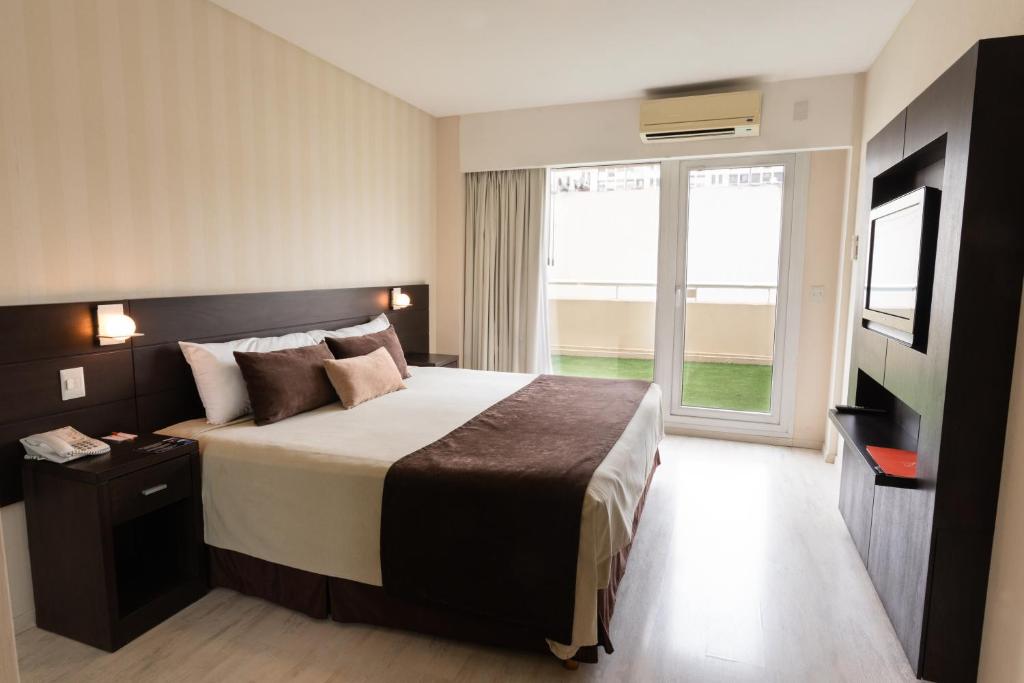 a hotel room with a bed and a large window at Icaro Suites in Buenos Aires