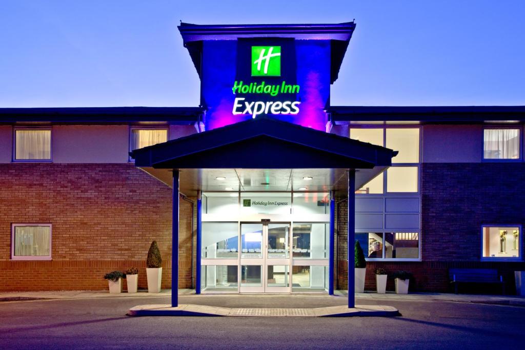 een gebouw met een neonbord ervoor bij Holiday Inn Express Shrewsbury, an IHG Hotel in Shrewsbury