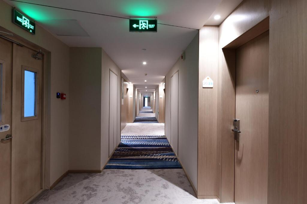 a corridor of a hallway with a sign on the ceiling at Holiday Inn Express Changchun High-Tech Zone by IHG in Changchun