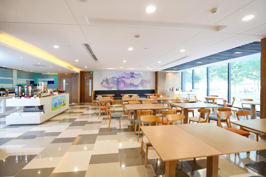 a restaurant with tables and chairs in a cafeteria at Holiday Inn Express Changchun High-Tech Zone by IHG in Changchun