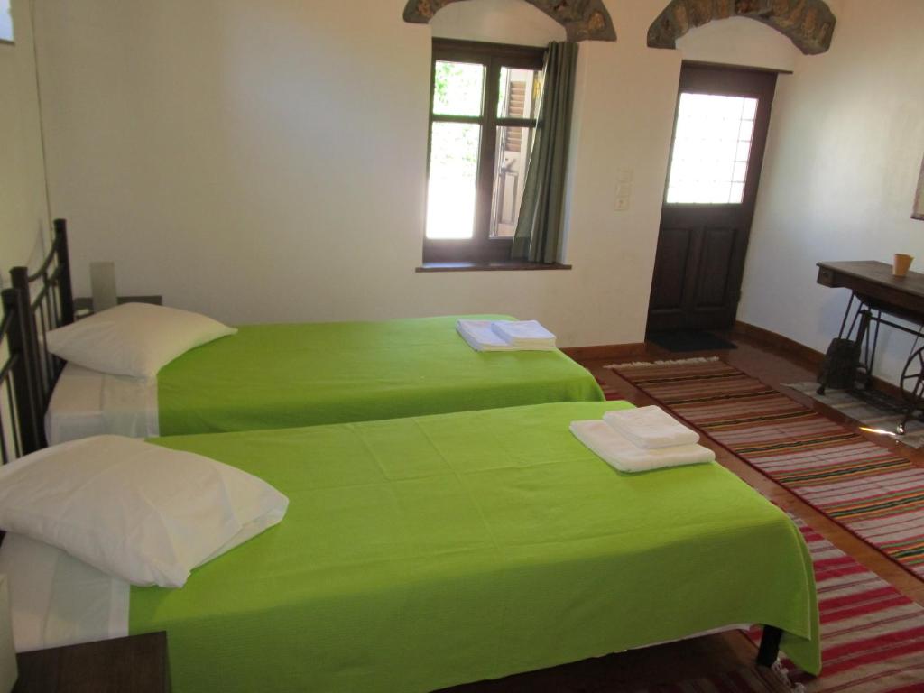 2 camas en una habitación con sábanas verdes en Guesthouse Ventista-Ξενώνας, en Theodoriana