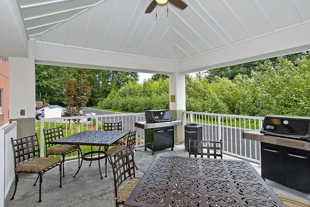 eine Terrasse mit einem Tisch und Stühlen sowie einem weißen Dach in der Unterkunft Candlewood Suites Burlington, an IHG Hotel in Burlington