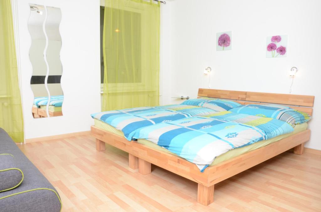 - une chambre dotée d'un lit avec des draps bleus et blancs dans l'établissement Guesthouse Casa Esperanza Basel, à Bâle