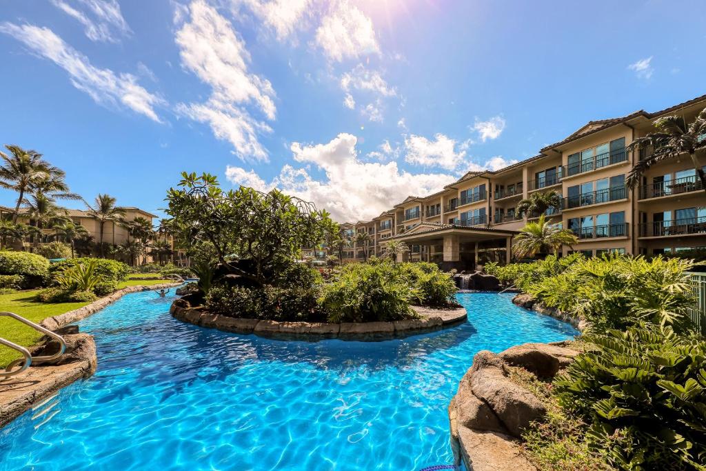 una piscina en un complejo con agua azul en Waipouli Beach Resort, en Kapaa