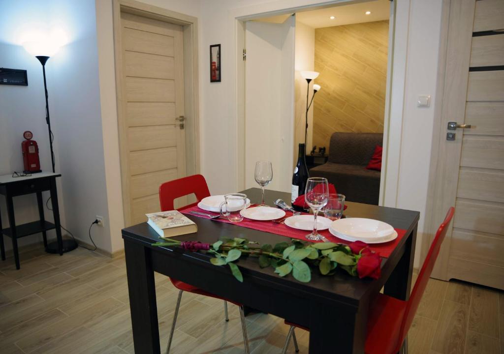 a dining table with wine glasses and red chairs at Niedaleko od Centrum ale Z dala od tłumów in Lublin