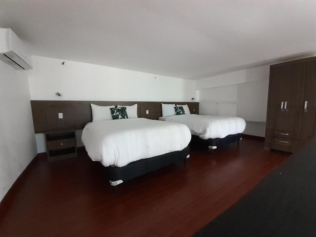 Postel nebo postele na pokoji v ubytování Innfiniti Hotel & Suites