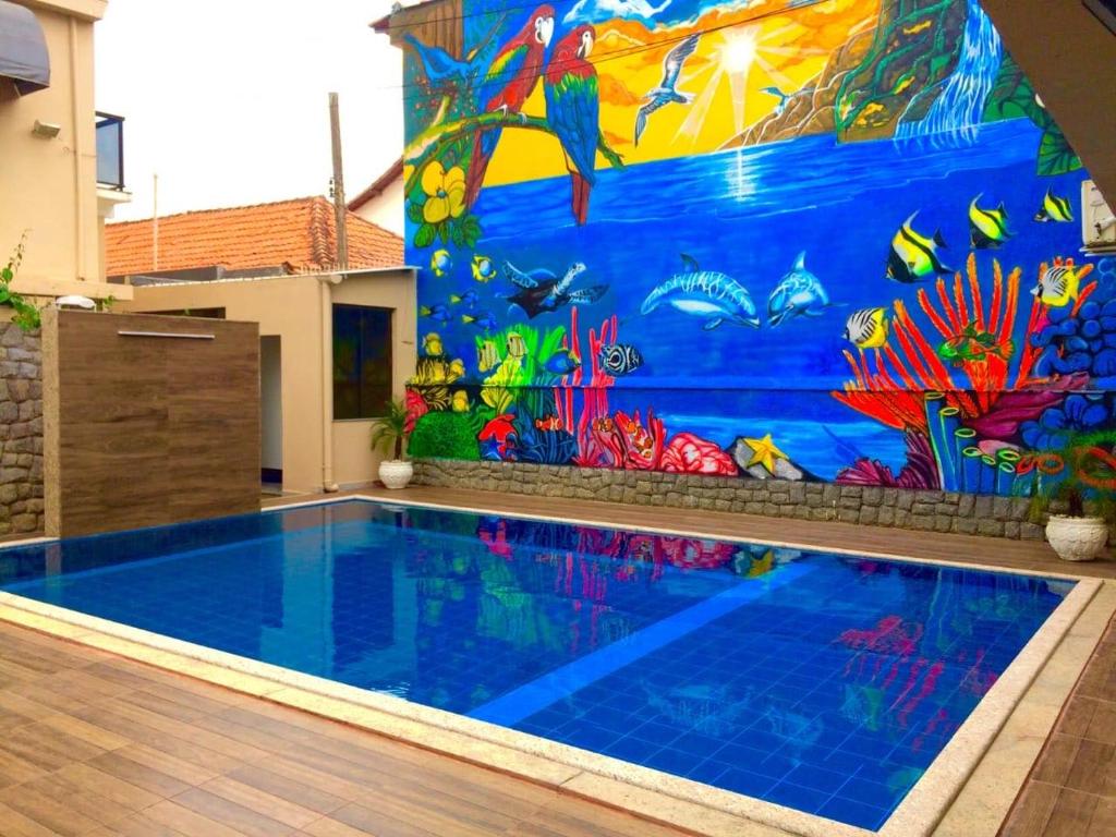 uma piscina com um mural de peixe na parede em Pousada Pinheiro em Campos dos Goytacazes