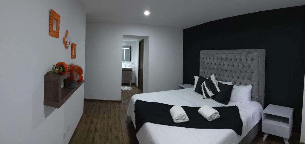ein Schlafzimmer mit einem großen Bett mit schwarzen und weißen Kissen in der Unterkunft VIVE BIOSFERA JURIQUILLA in Querétaro