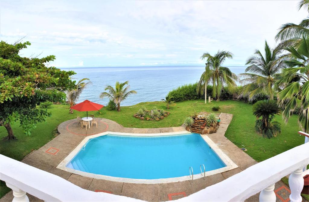 una piscina all'aperto con vista sull'oceano sullo sfondo di Cabaña PEDREGAL a Puerto Escondido