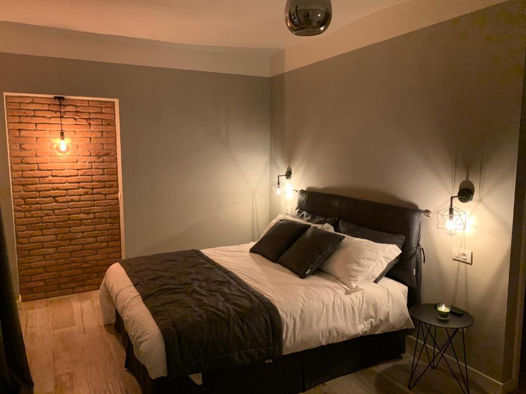 ein Schlafzimmer mit einem Bett und einer Ziegelwand in der Unterkunft Laficaia in Mombaruzzo