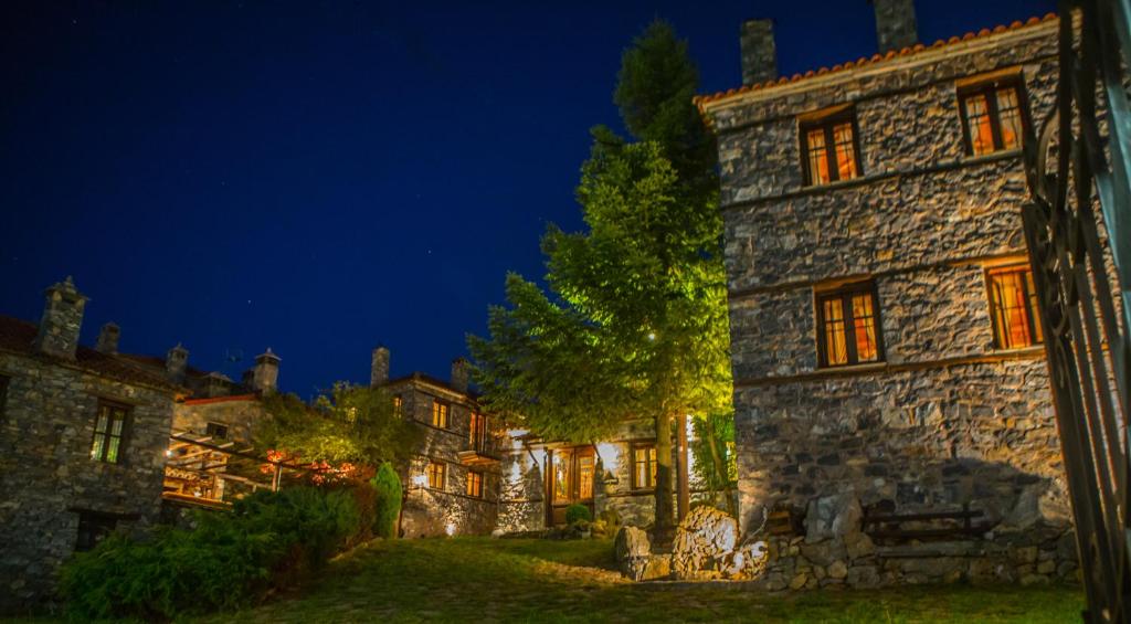 an old stone building at night with lights on at 4 Seasons Premium Chalet in Palaios Agios Athanasios