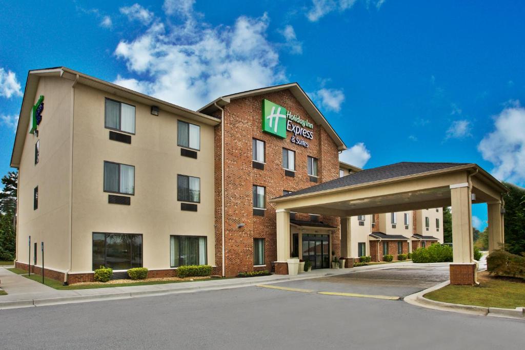 un hotel con un cartel en la parte delantera de un edificio en Holiday Inn Express & Suites Buford NE - Lake Lanier Area, an IHG Hotel, en Buford