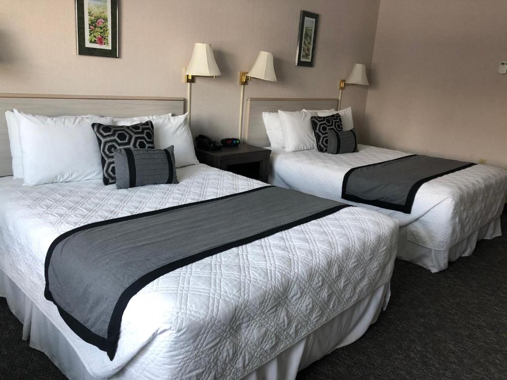 two beds in a hotel room with white and black pillows at Aurora Denali Lodge in Healy