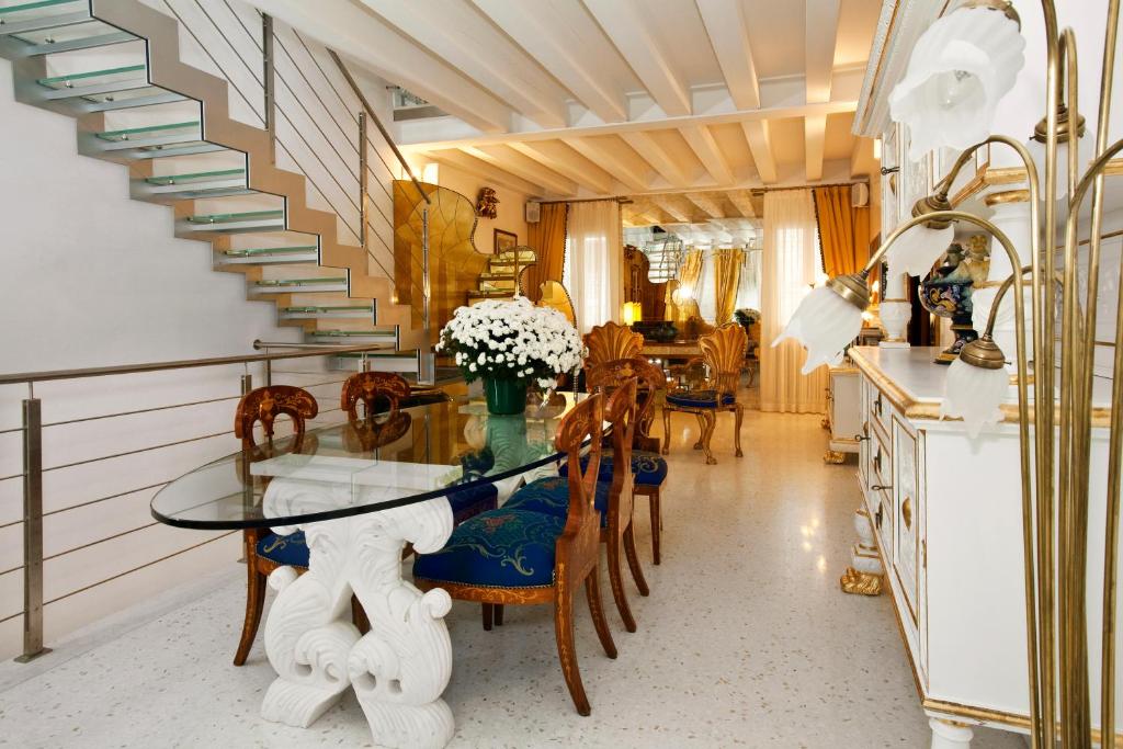 comedor con mesa de cristal y sillas en Casa Fortuny Luxury Apartment, en Venecia