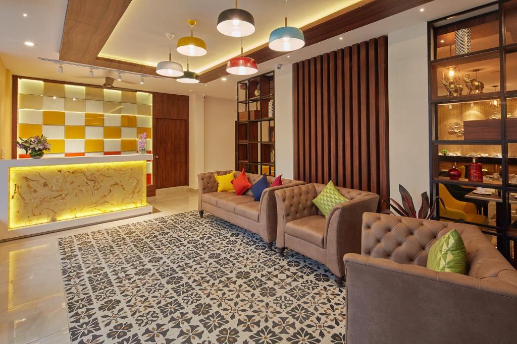 a living room with couches and a rug at Regenta Inn Indiranagar by Royal Orchid Hotels in Bangalore
