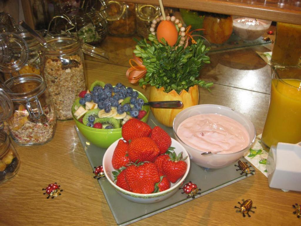 a table topped with bowls of fruit and dip at Gästehaus Ainser in Hagnau
