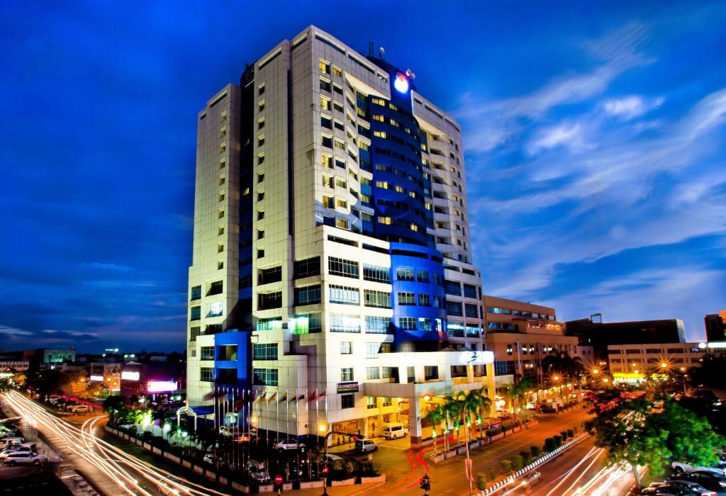 a tall building in a city at night at Mega Hotel in Miri