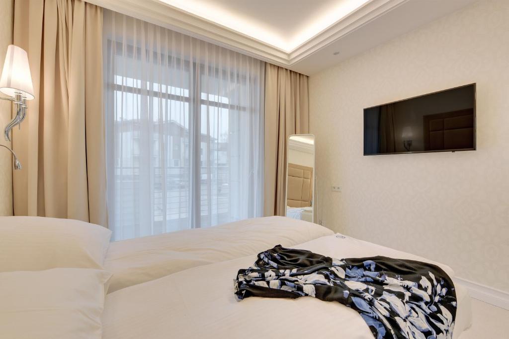 a hotel room with a bed and a flat screen tv at Grand Apartments - Neptun Park. in Gdańsk