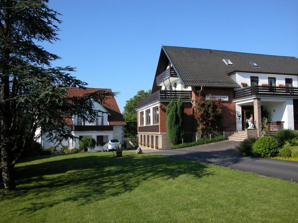 una casa grande con un césped verde delante de ella en Hotel Landhaus Lahmann, en Bad Eilsen