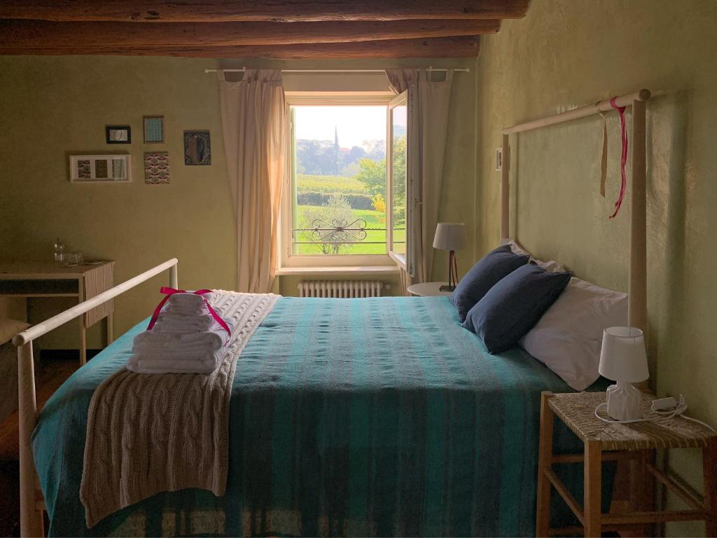 um quarto com uma cama grande e uma janela em A casa di Hugo em Marano di Valpolicella