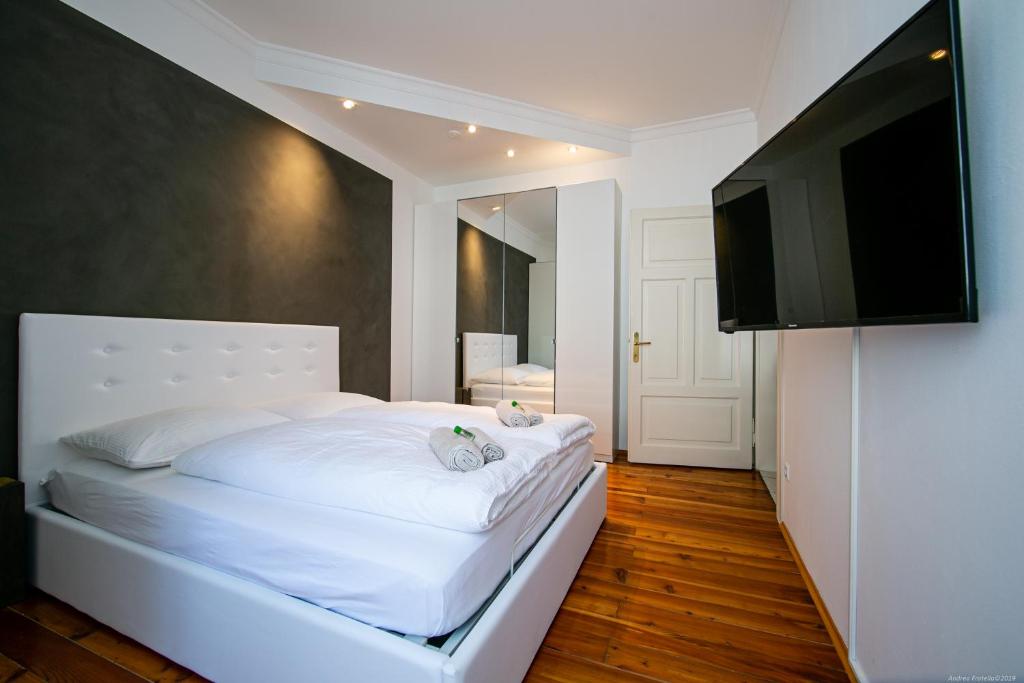 een slaapkamer met een wit bed en een flatscreen-tv bij Apartment Andreas in Bolzano