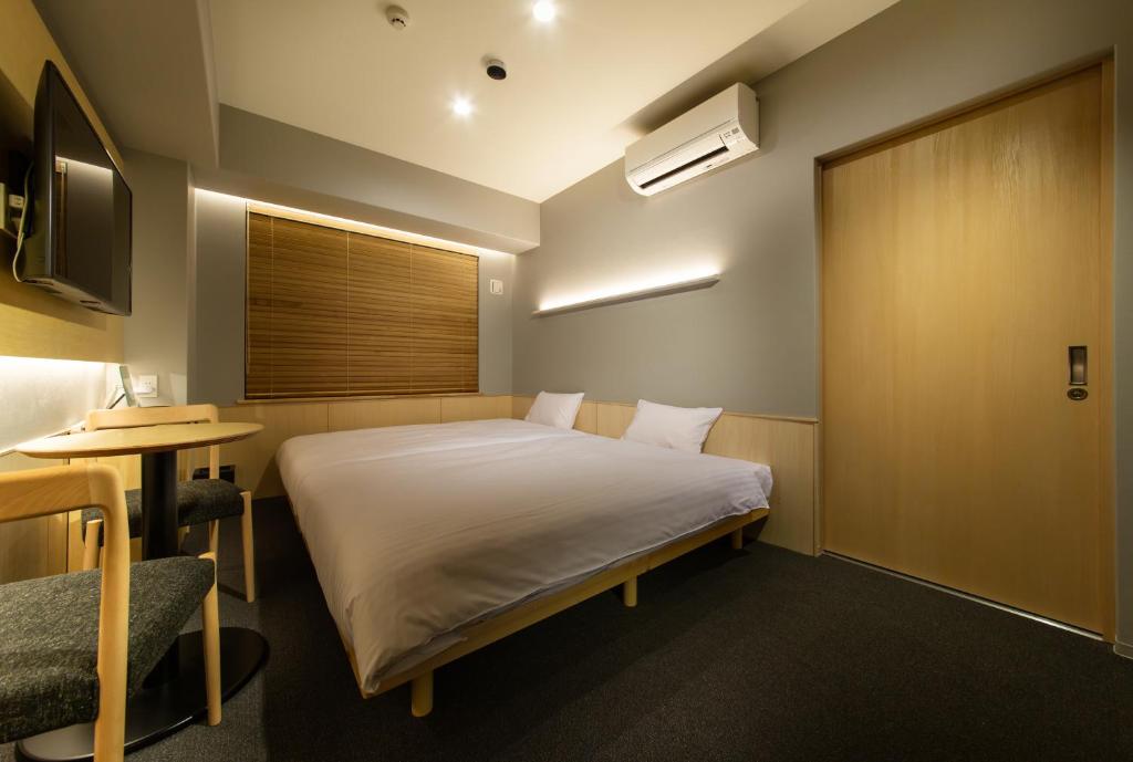Rúm í herbergi á HOTEL AMANEK Kyoto Kawaramachi Gojo