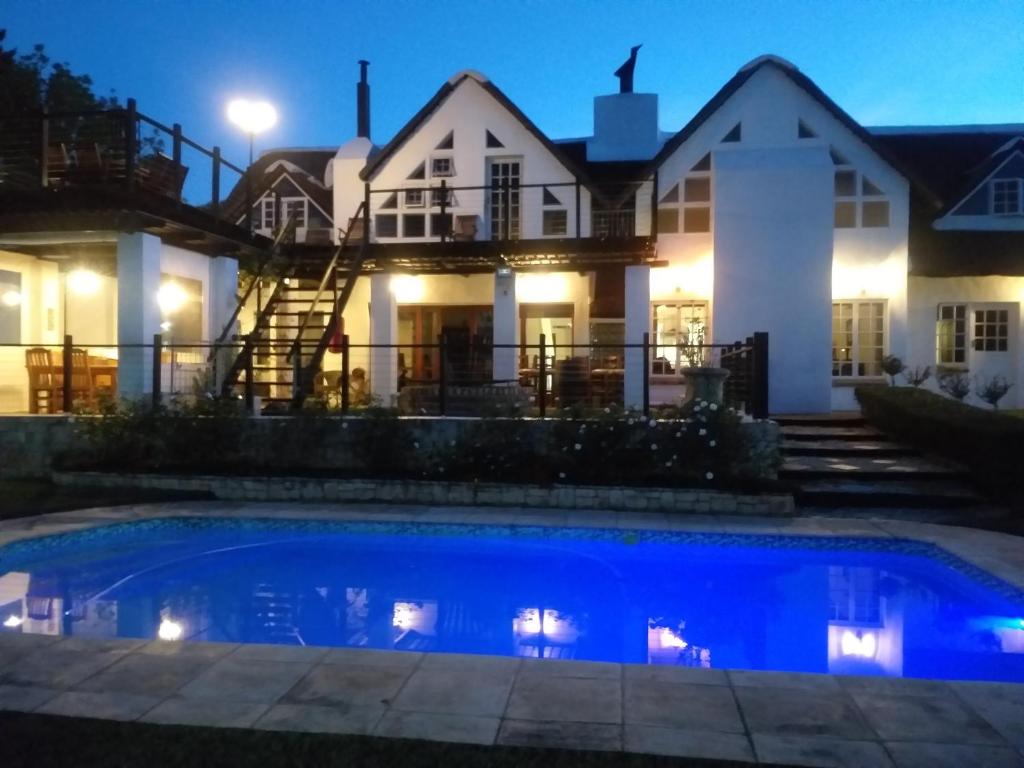 a house with a swimming pool at night at Little Tree Loft in Uitenhage
