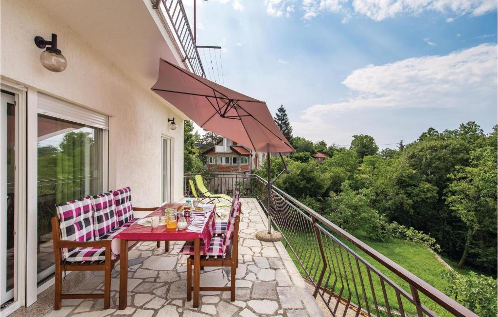 a patio with a table and chairs and an umbrella at Beautiful Apartment In Jurdani With Kitchen in Jurdani
