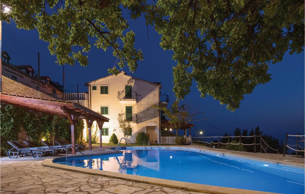 una villa con piscina di notte di Pet Friendly Home In Podstrana With Jacuzzi a Podstrana