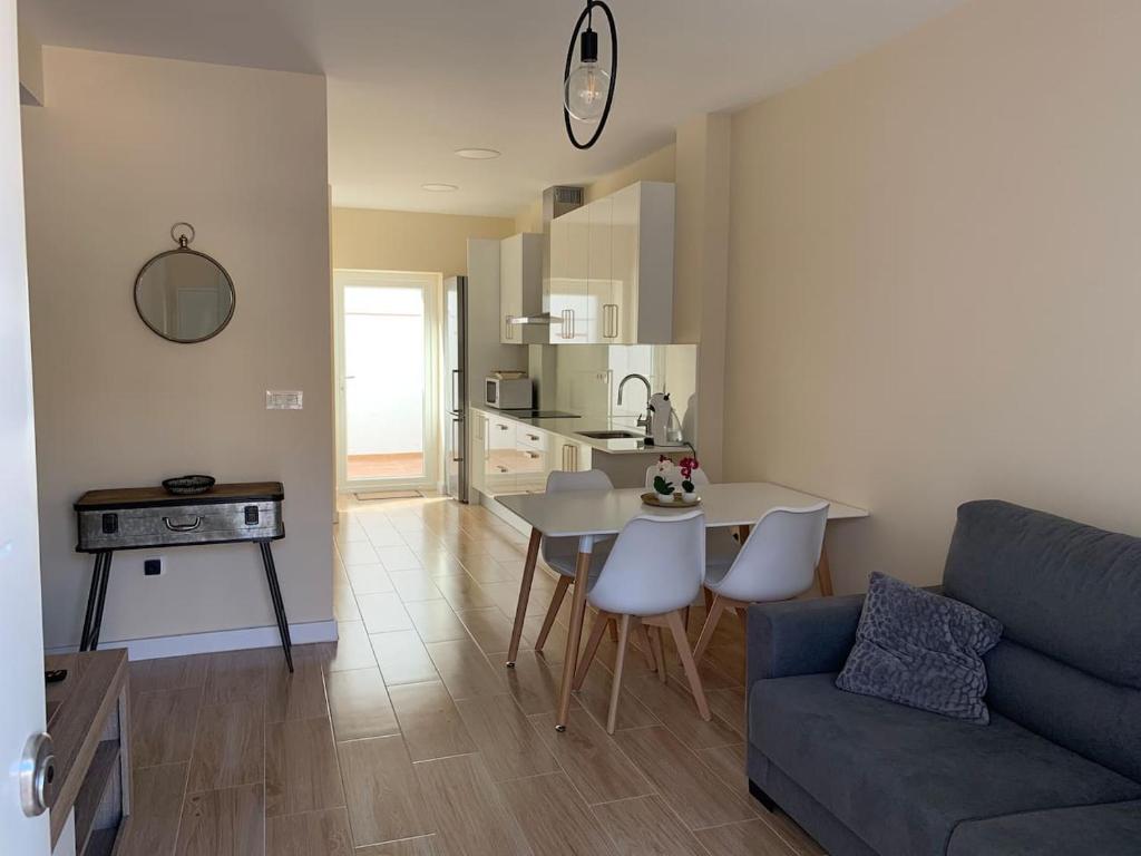 een woonkamer met een bank en een tafel en een keuken bij Casita en Granada in Granada