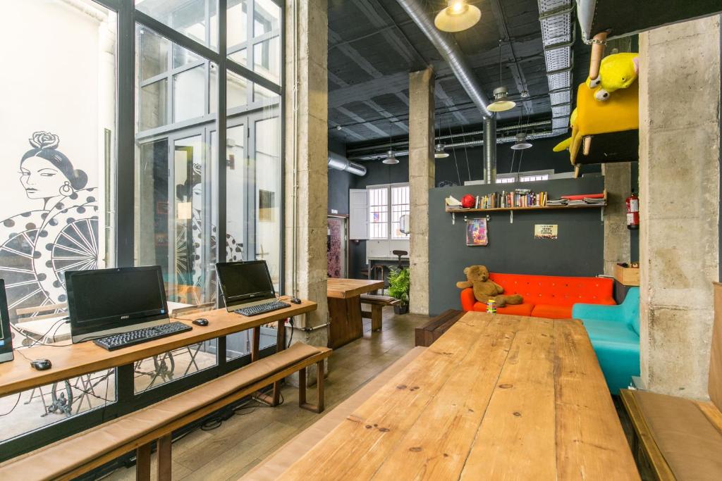 a living room filled with furniture and a computer at Black Swan Hostel Sevilla in Seville