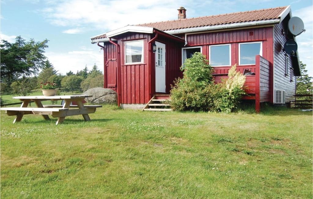 eine rote Hütte mit einem Picknicktisch davor in der Unterkunft Holiday Home Farsund Krågenes in Farsund
