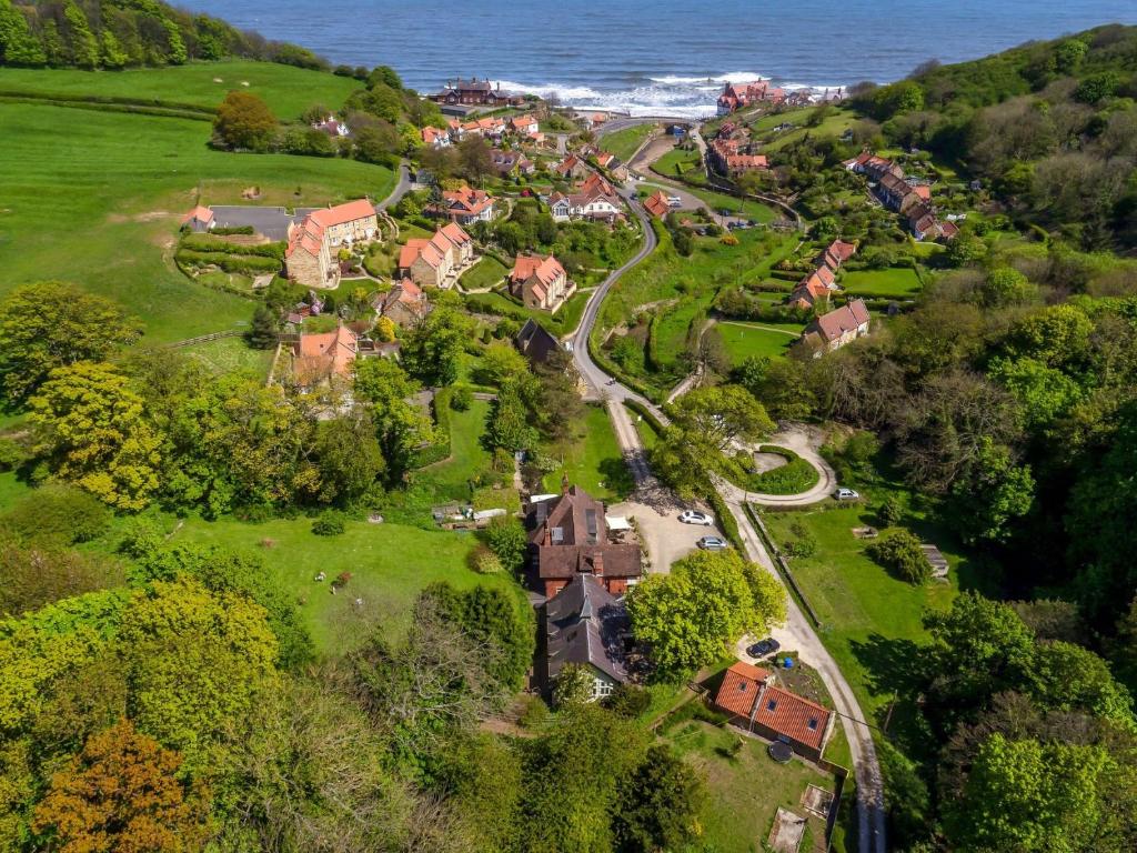 une vue aérienne sur un village avec des maisons et une route dans l'établissement The Woodlands, à Sandsend