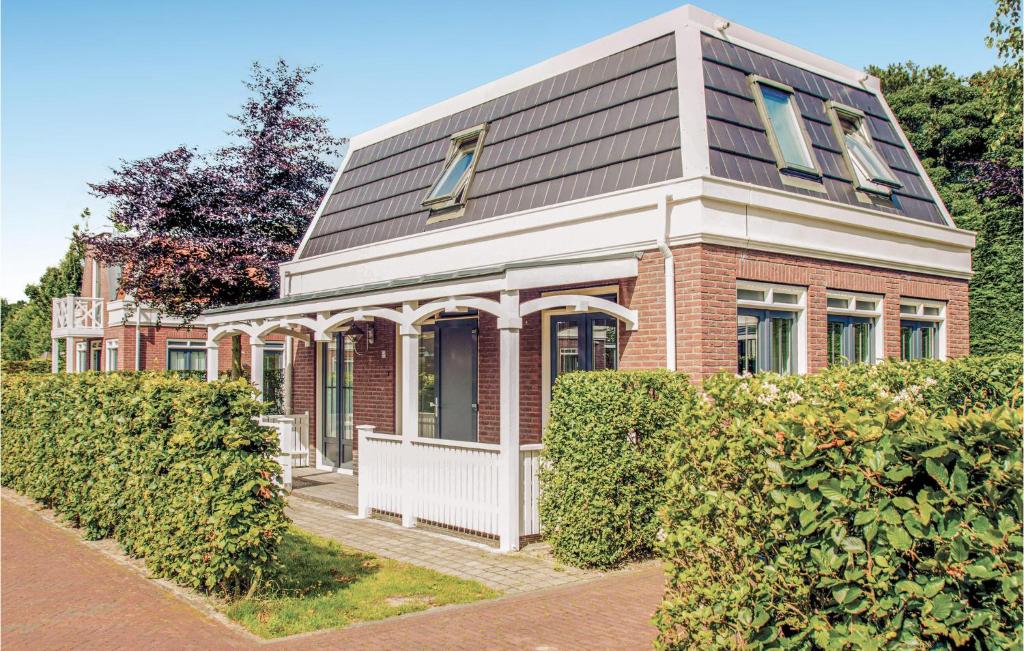 a red brick house with a gambrel roof at Tulp En Zee 6 Persoons in Noordwijk aan Zee