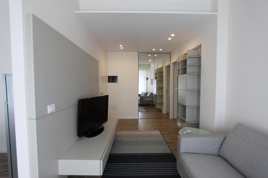 a living room with a couch and a tv on a wall at casa Agrifoglio in Terralba