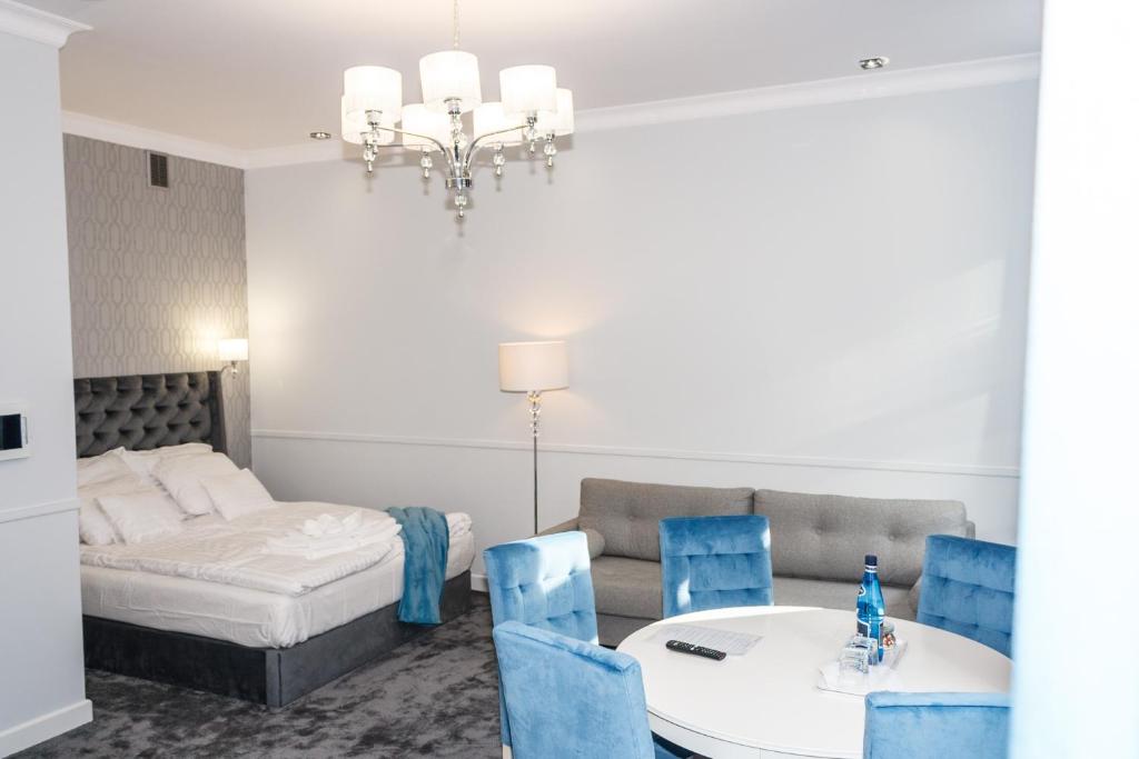 Un dormitorio con una cama y una mesa y sillas. en Apartamenty Hexus - Ofiar Oświęcimskich - Wrocław centrum Rynek, en Wroclaw