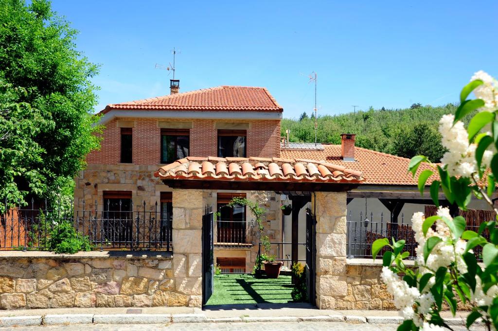 una casa de ladrillo con porche y valla en Lagunas de Urbión en Molinos de Duero
