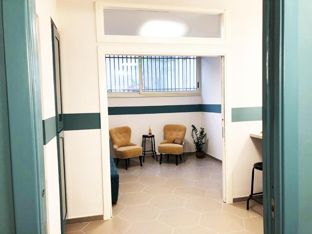 - un couloir avec deux chaises et une table dans une chambre dans l'établissement Hostellino, à Naples