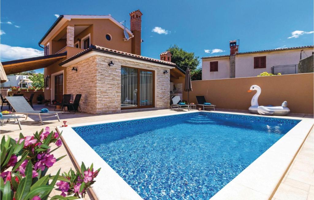 a villa with a swimming pool in front of a house at 2 Bedroom Lovely Home In Pula in Pula