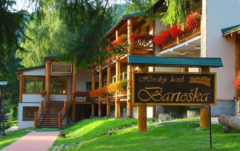 un grand bâtiment avec un panneau devant lui dans l'établissement Hotel Bartoška, à Turčianske Teplice