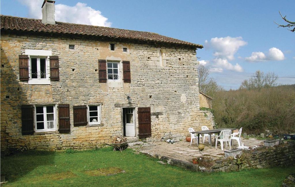 an old stone house with a table and chairs in front of it at Holiday Home Le Coussot in Beaulieu-sur-Sonnette