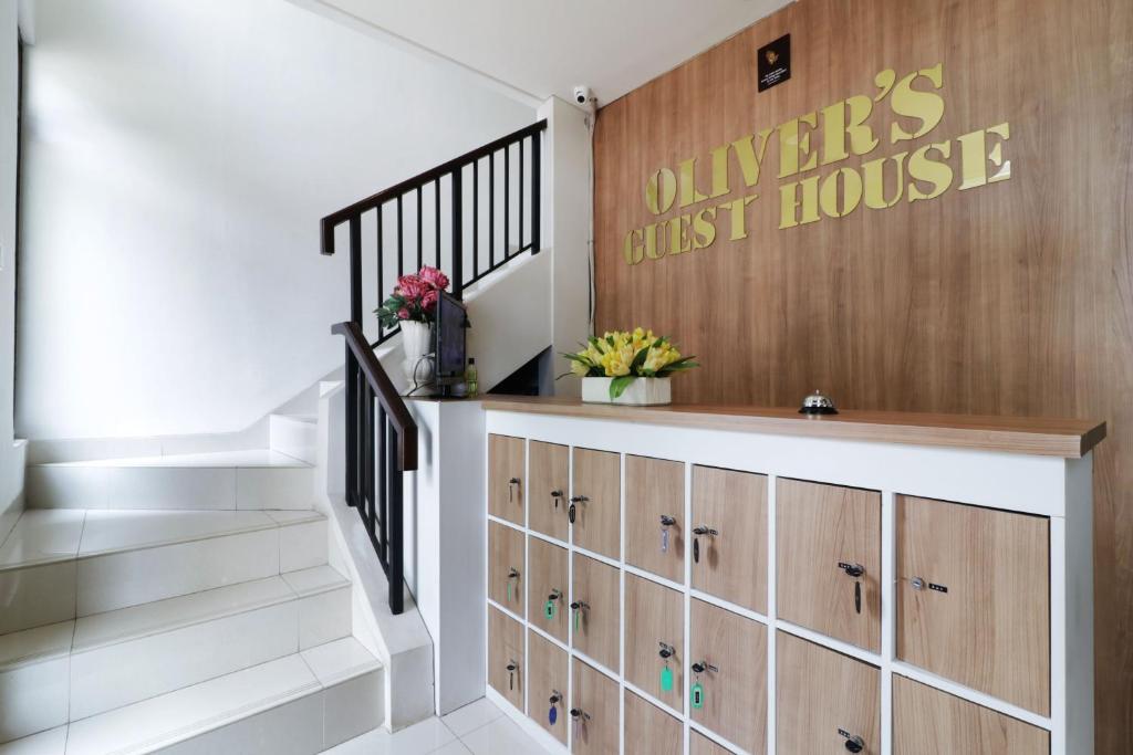 a staircase with wooden cabinets and a first house sign at Oliver's Guest House in Tangerang